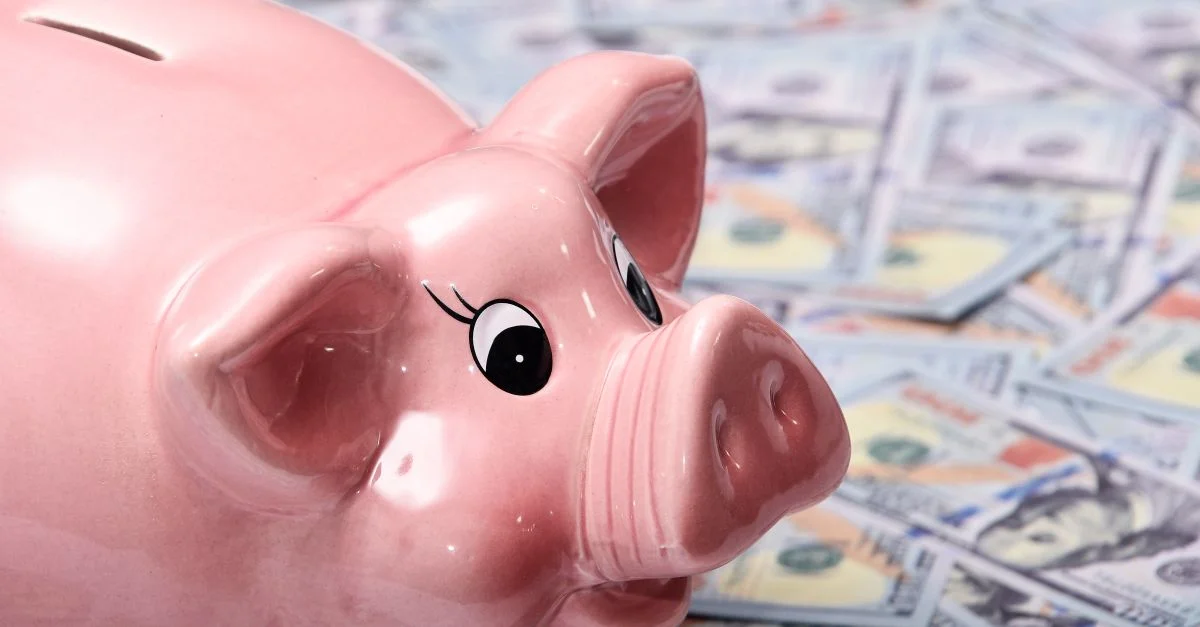 Yellow piggy bank on a stack of US dollar bills
