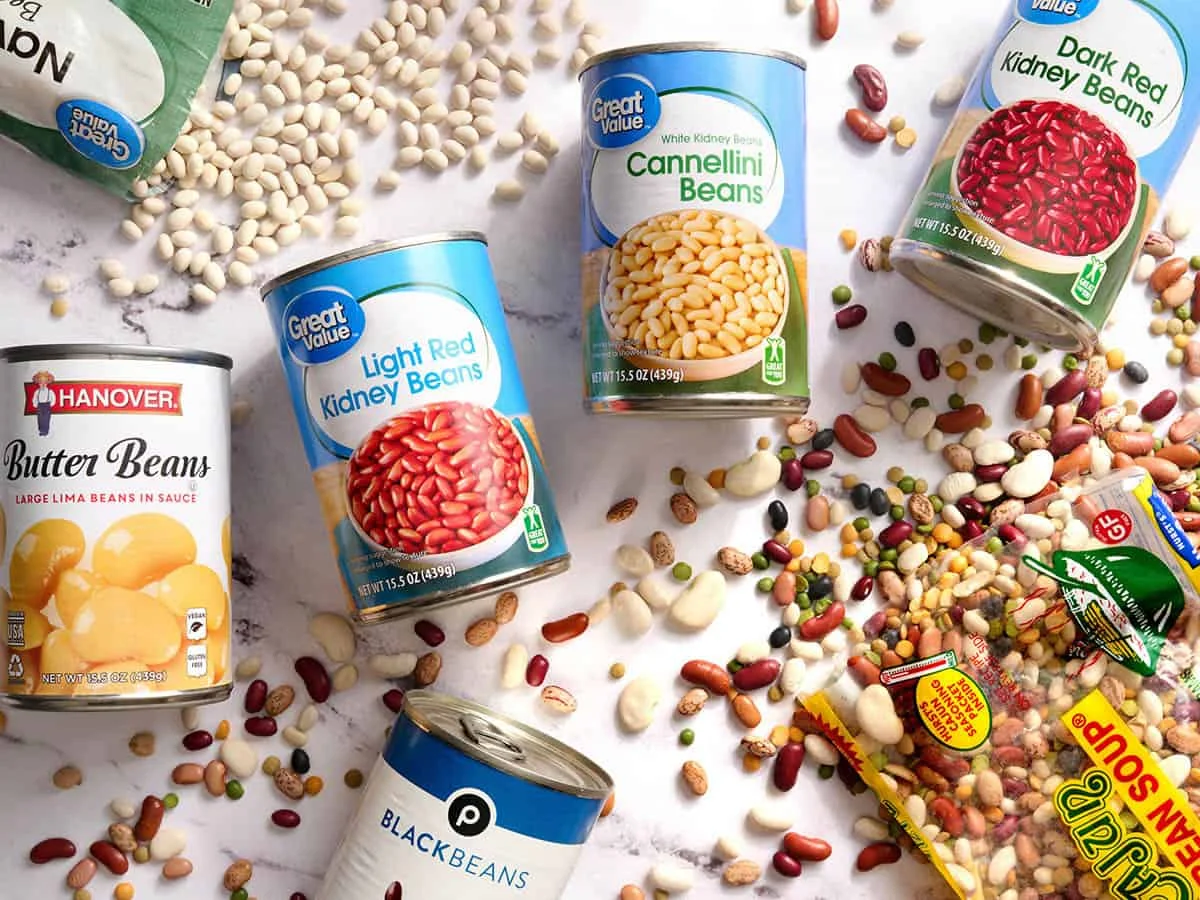 Canned and dried beans arranged on marble surface