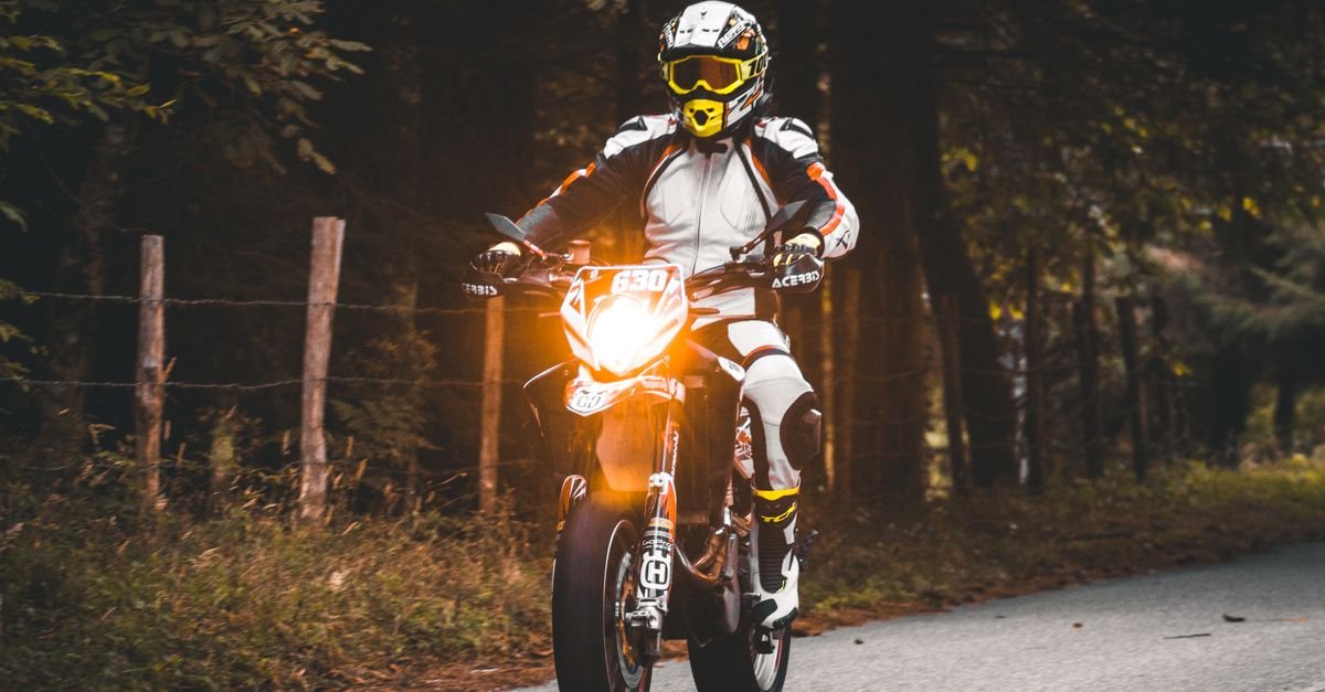 Motorcyclist in full gear riding a rural road