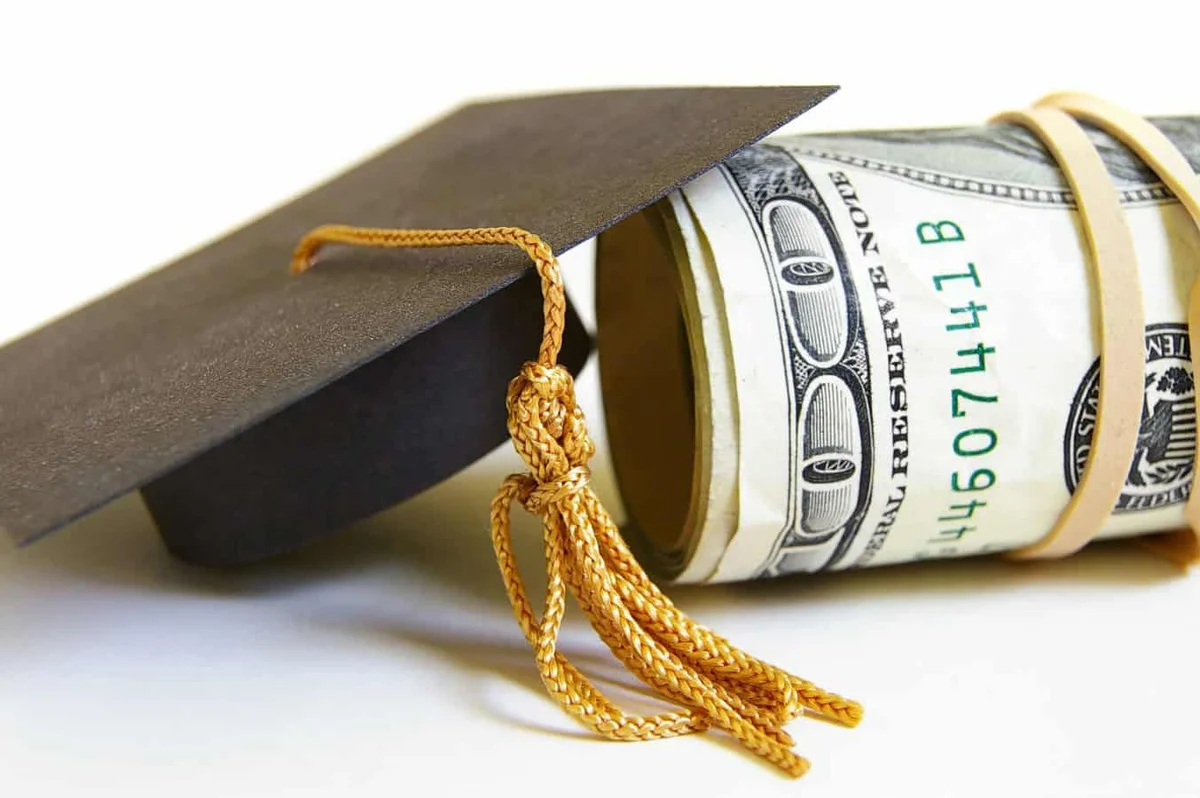 Graduation cap resting next to a student loan document